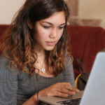 Young Woman Studies On Computer at Home for Higher Education